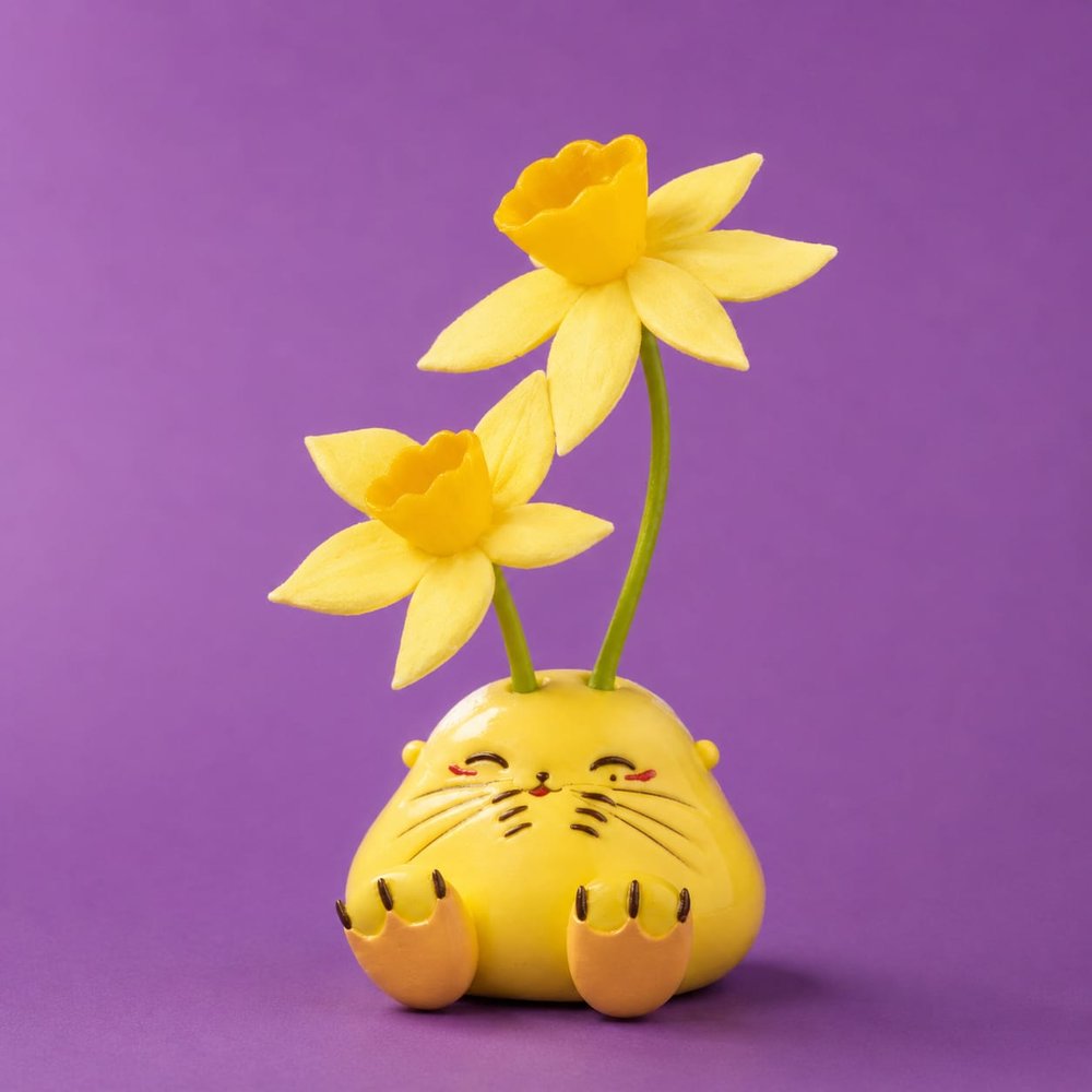 A yellow Humulus figure with two daffodils growing from his head