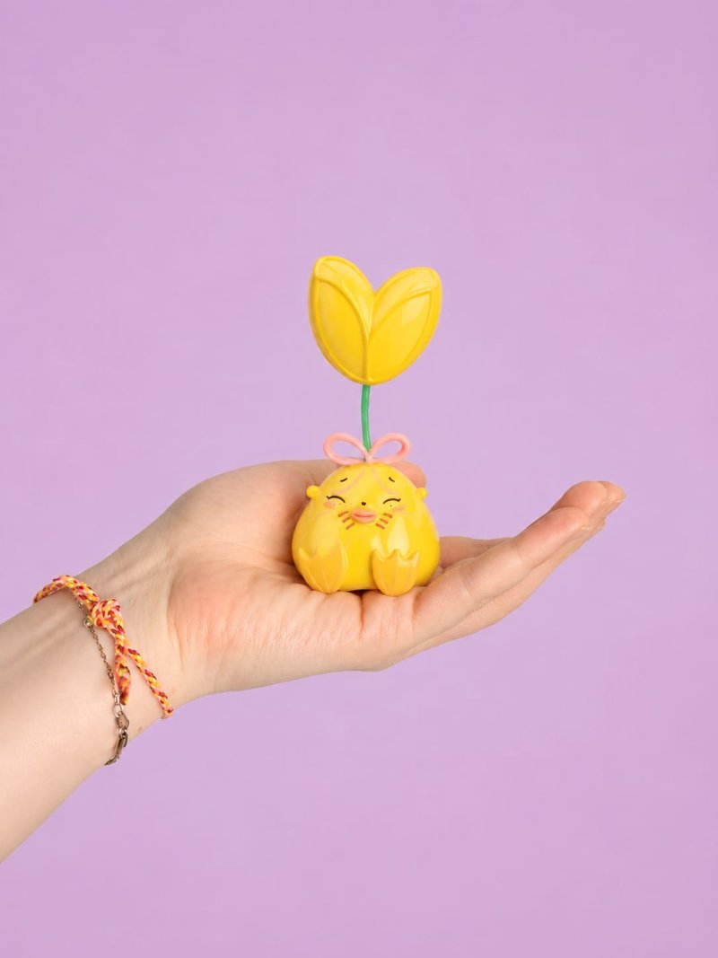 A smiling Humulus figure with a yellow tulip, resting on a palm